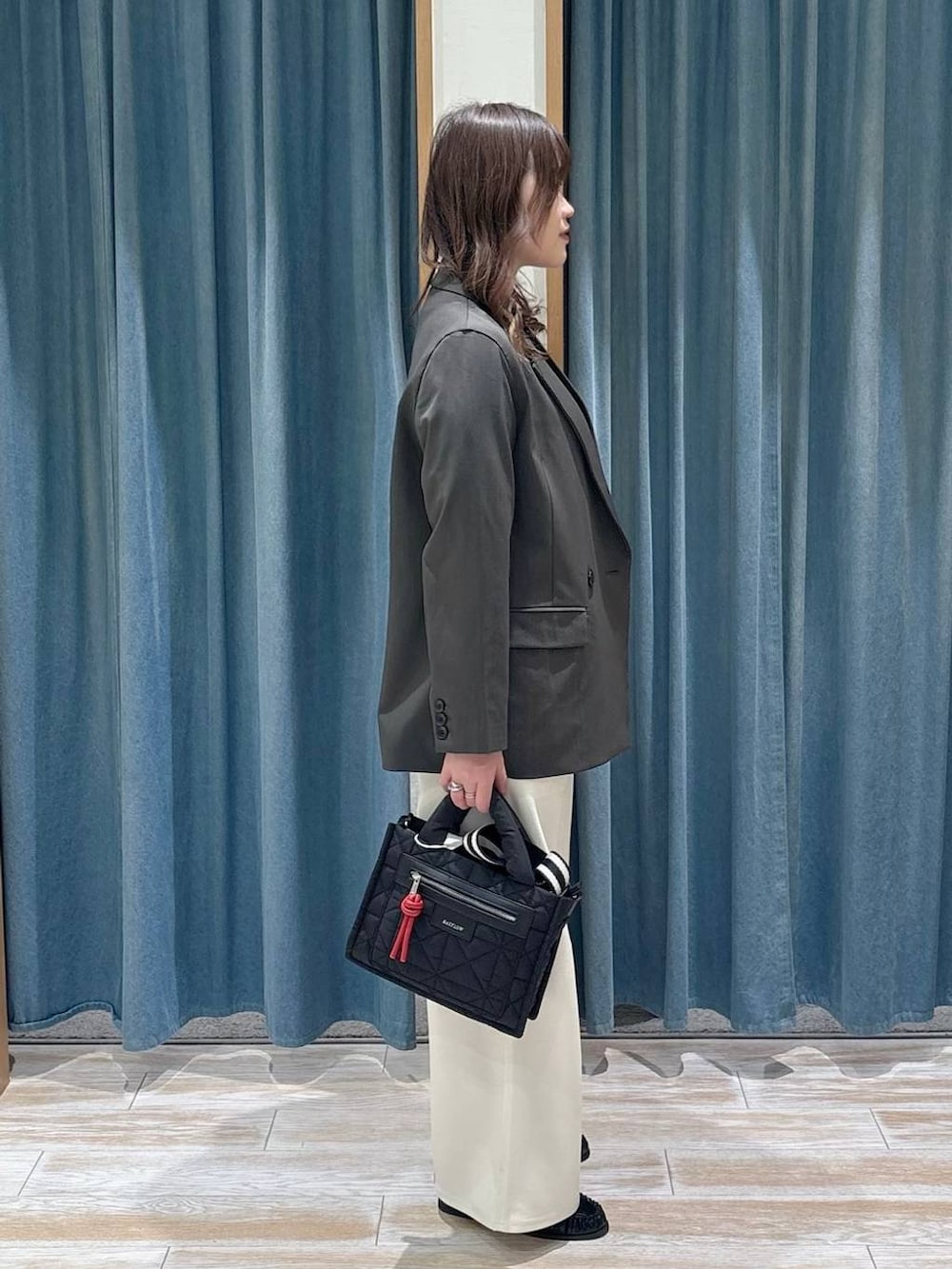 ブラック系のショルダーバッグ、ブラック系のTシャツ/カットソー、ホワイト系のその他パンツを着用したレディースの冬コーディネートの2枚目の写真