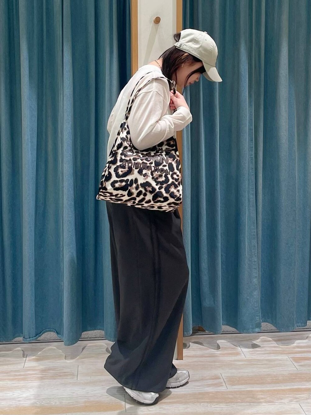 グレー系のその他パンツ、ベージュ系のトートバッグ、ホワイト系のニット/セーターを着用したレディースの春コーディネートの2枚目の写真