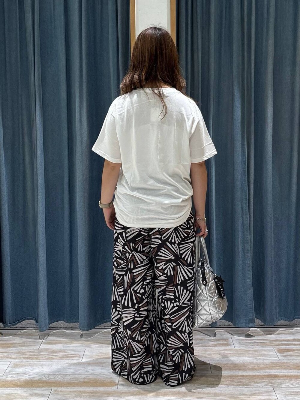 ホワイト系のTシャツ/カットソー、ブラック系のその他パンツ、シルバー系のトートバッグを着用したレディースの夏コーディネートの3枚目の写真