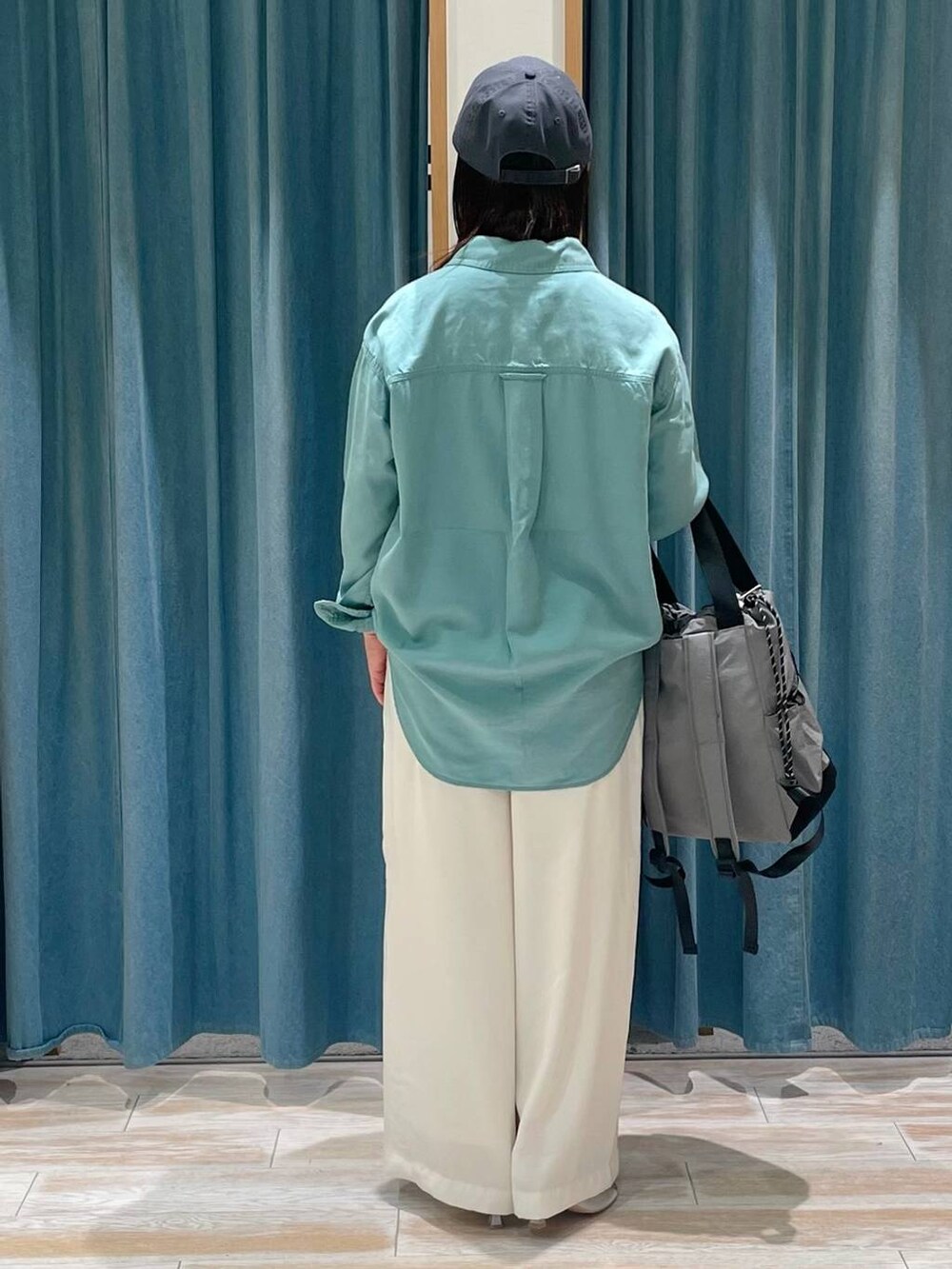 グリーン系のシャツ/ブラウス、ホワイト系のその他パンツ、グレー系のバックパック/リュックを着用したレディースの春コーディネートの3枚目の写真