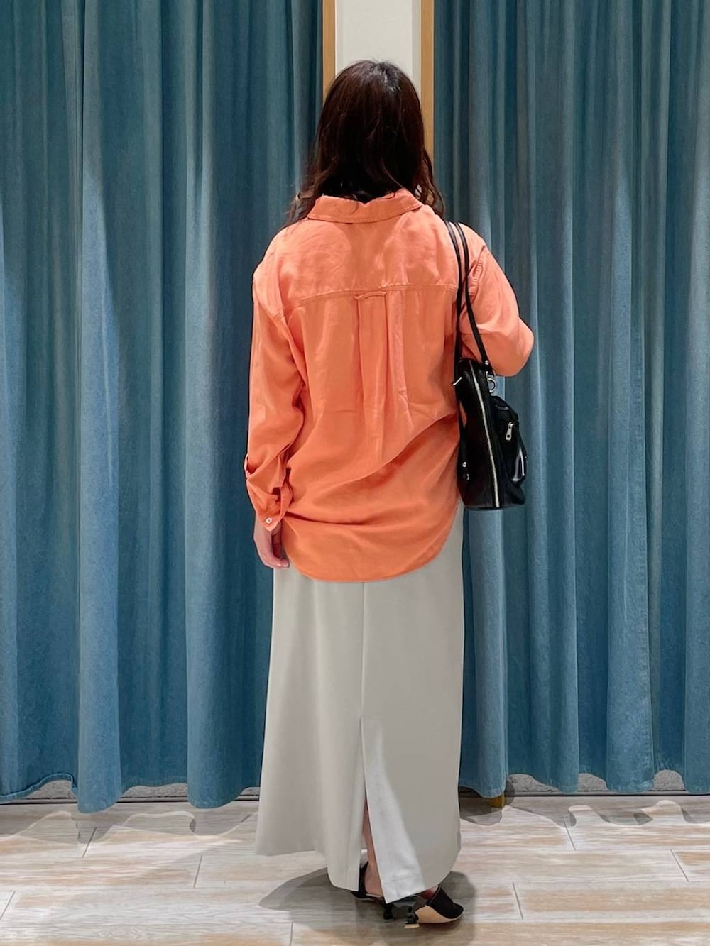 オレンジ系のシャツ/ブラウス、ブラック系のサンダル、グレー系のスカートを着用したレディースの春コーディネートの3枚目の写真