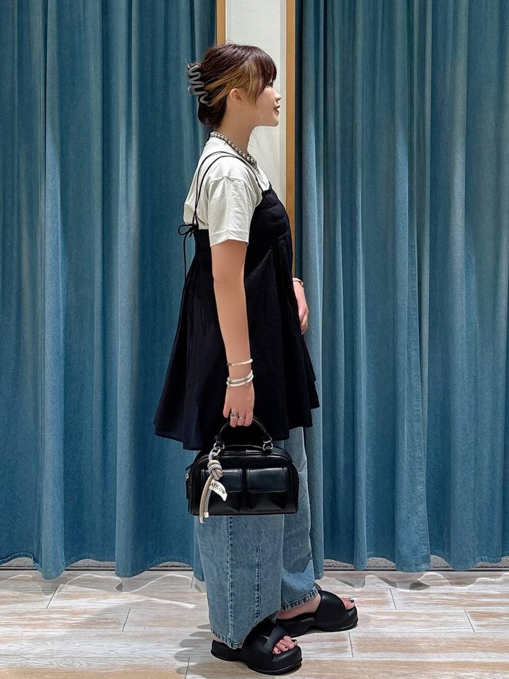 ベージュ系のTシャツ/カットソー、ブルー系のデニムパンツ、ブラック系のキャミソールを着用したレディースの夏コーディネートの2枚目の写真