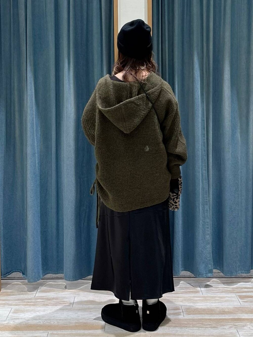 ブラウン系のショルダーバッグ、ブラック系のブーツ、ブラック系のスカートを着用したレディースの秋コーディネートの3枚目の写真