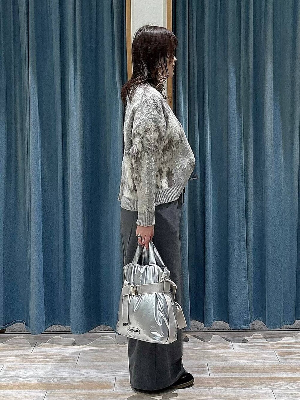 シルバー系のトートバッグ、グレー系のその他パンツ、ブラック系のスニーカーを着用したレディースの冬コーディネートの2枚目の写真