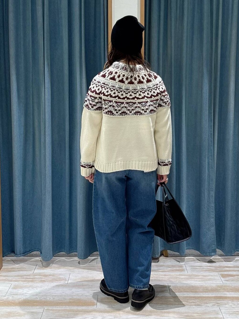 ブラック系のローファー、ブラック系のハンドバッグ、ホワイト系のニット/セーターを着用したレディースの秋コーディネートの3枚目の写真