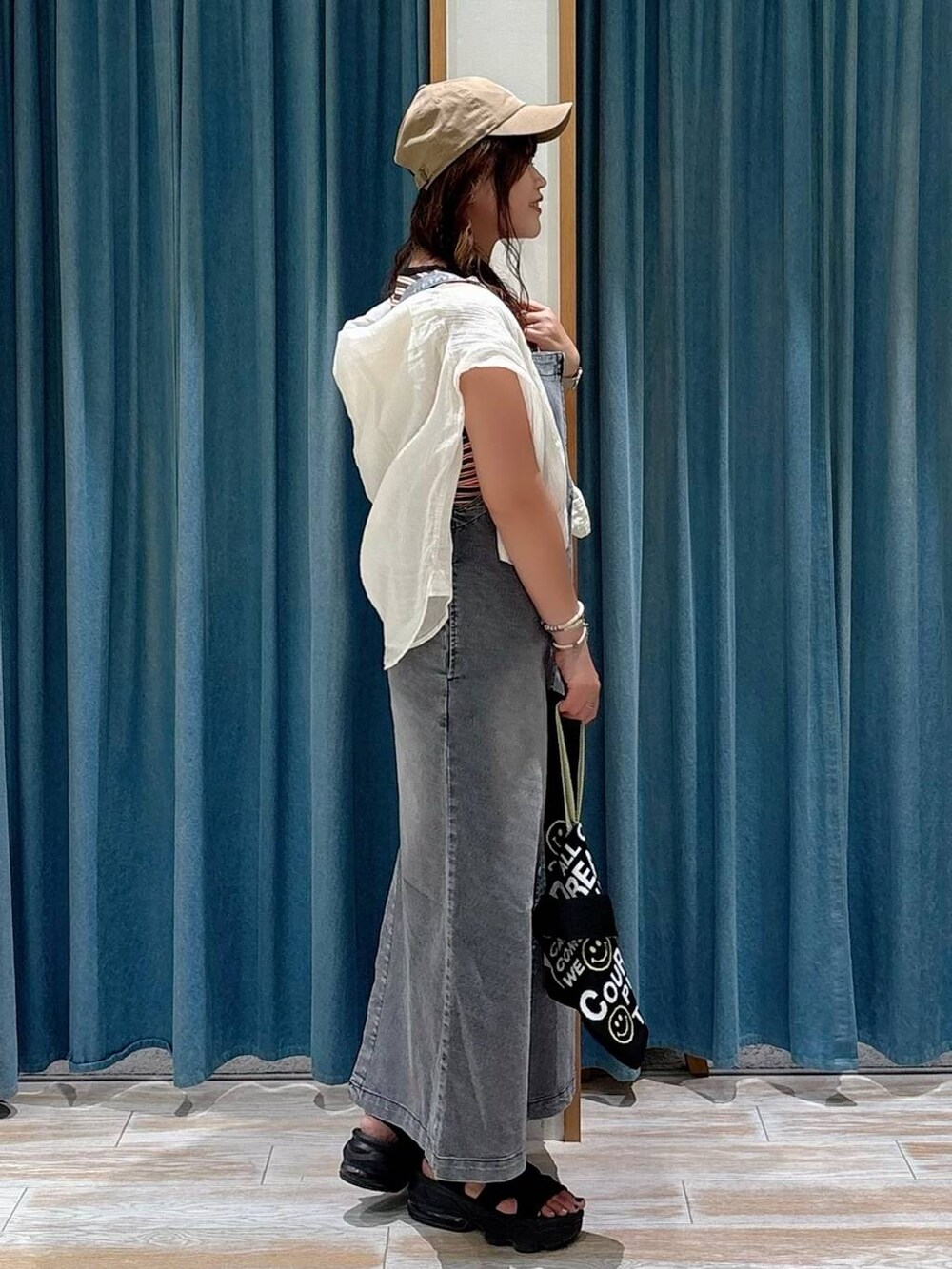 ホワイト系のシャツ/ブラウス、ブラック系のトートバッグ、ブラック系のジャンパースカートを着用したレディースの夏コーディネートの2枚目の写真