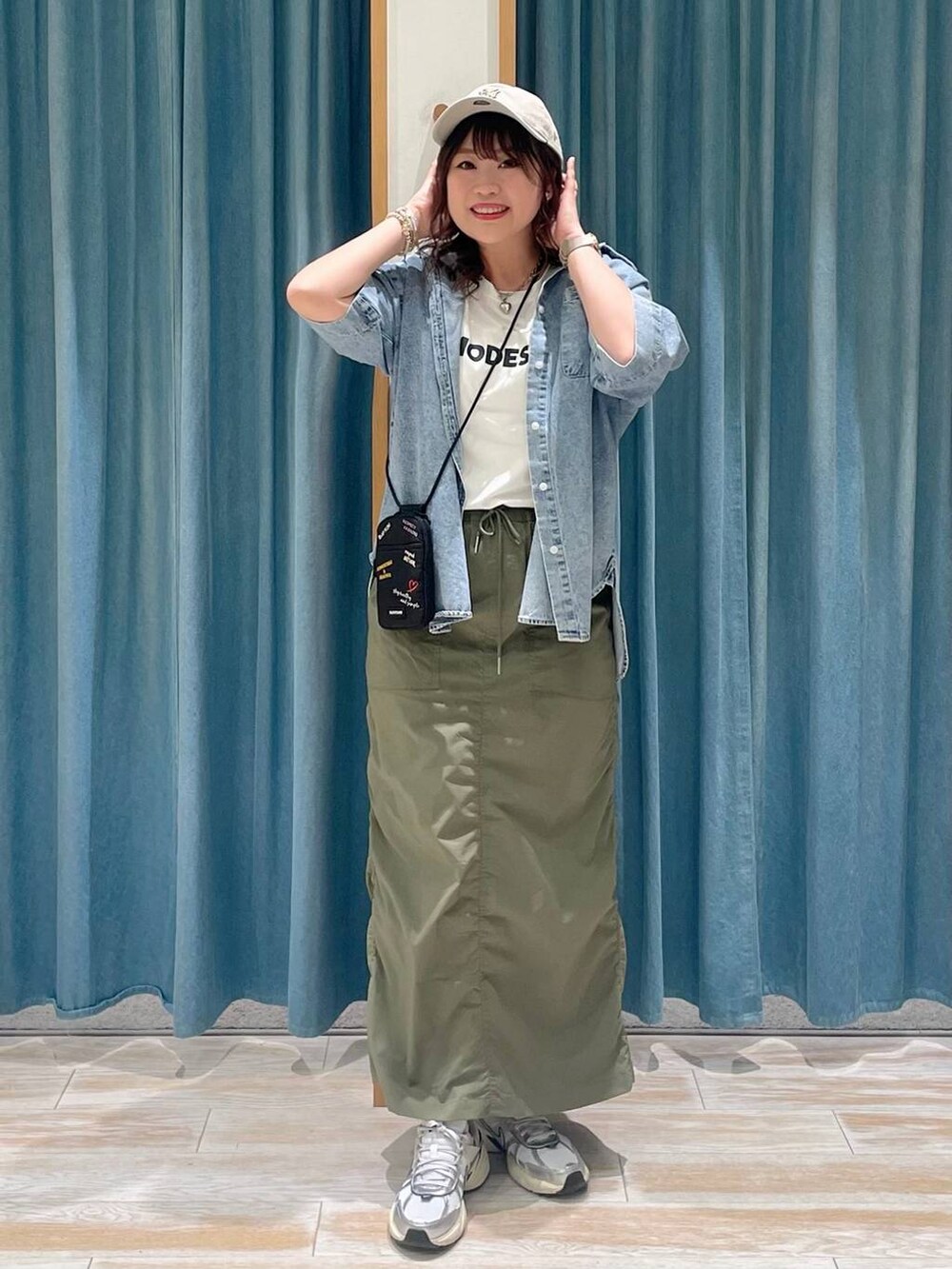 ホワイト系のTシャツ/カットソー、グリーン系のスカート、ブルー系のシャツ/ブラウスを着用したレディースの春コーディネートの3枚目の写真