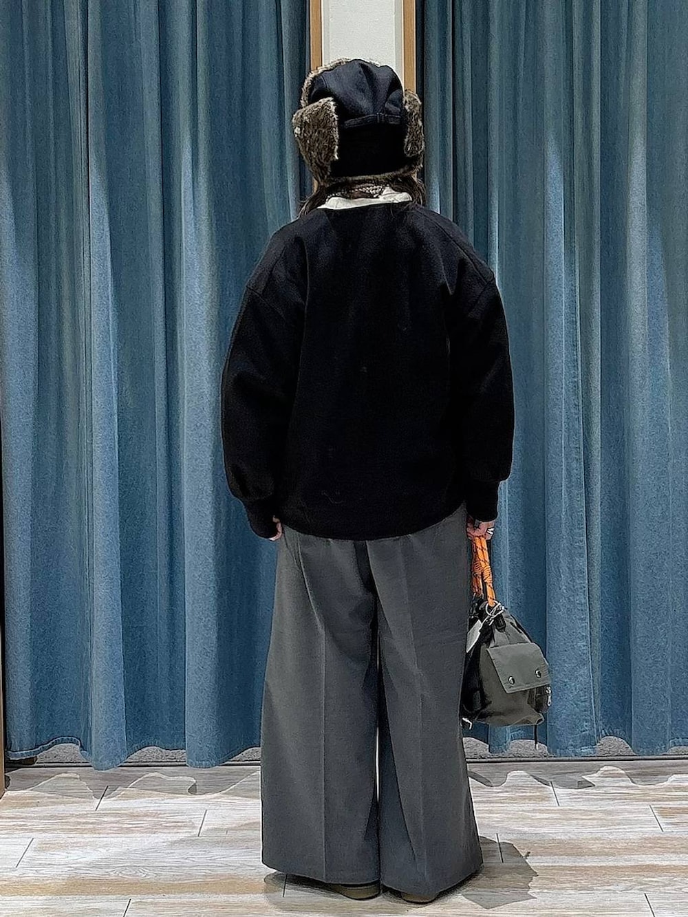 グレー系のその他パンツ、ブラック系のスニーカー、グリーン系のハンドバッグを着用したレディースの冬コーディネートの3枚目の写真