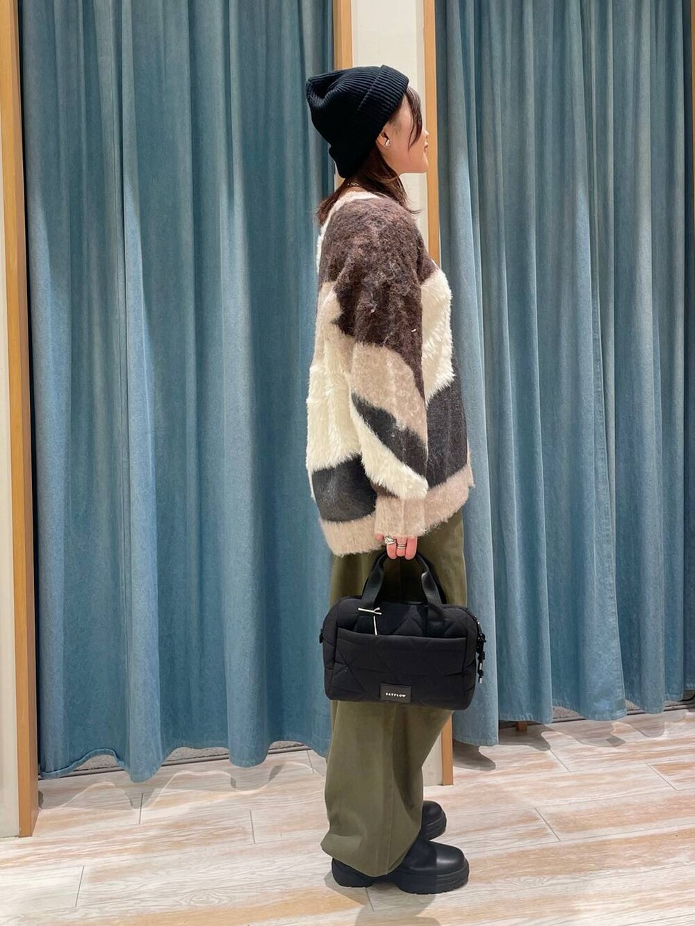 グリーン系のその他パンツ、ブラック系のブーツ、ブラウン系のカーディガン/ボレロを着用したレディースの冬コーディネートの2枚目の写真