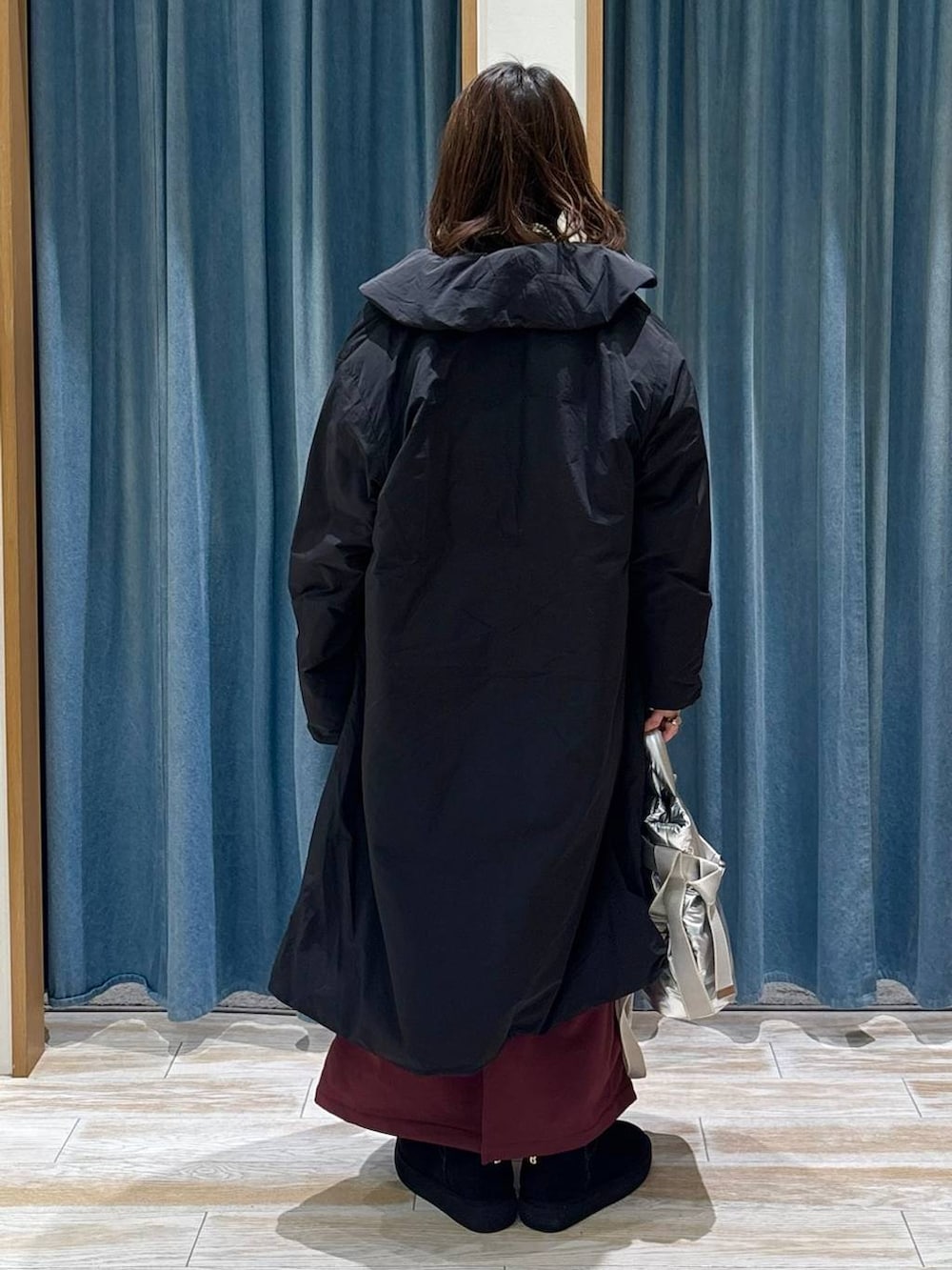 シルバー系のトートバッグ、レッド系のスカート、ブラック系のブーツを着用したレディースの秋コーディネートの3枚目の写真