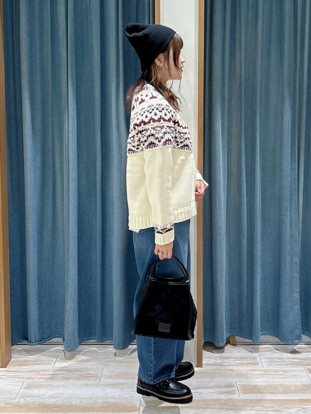 ブラック系のローファー、ブラック系のハンドバッグ、ホワイト系のニット/セーターを着用したレディースの秋コーディネートの2枚目の写真