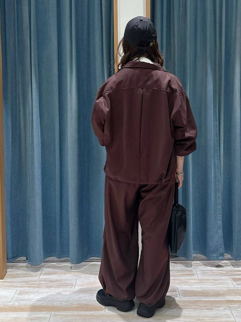 ブラック系のブーツ、ホワイト系のTシャツ/カットソー、ブラック系のハンドバッグを着用したレディースの秋コーディネートの3枚目の写真