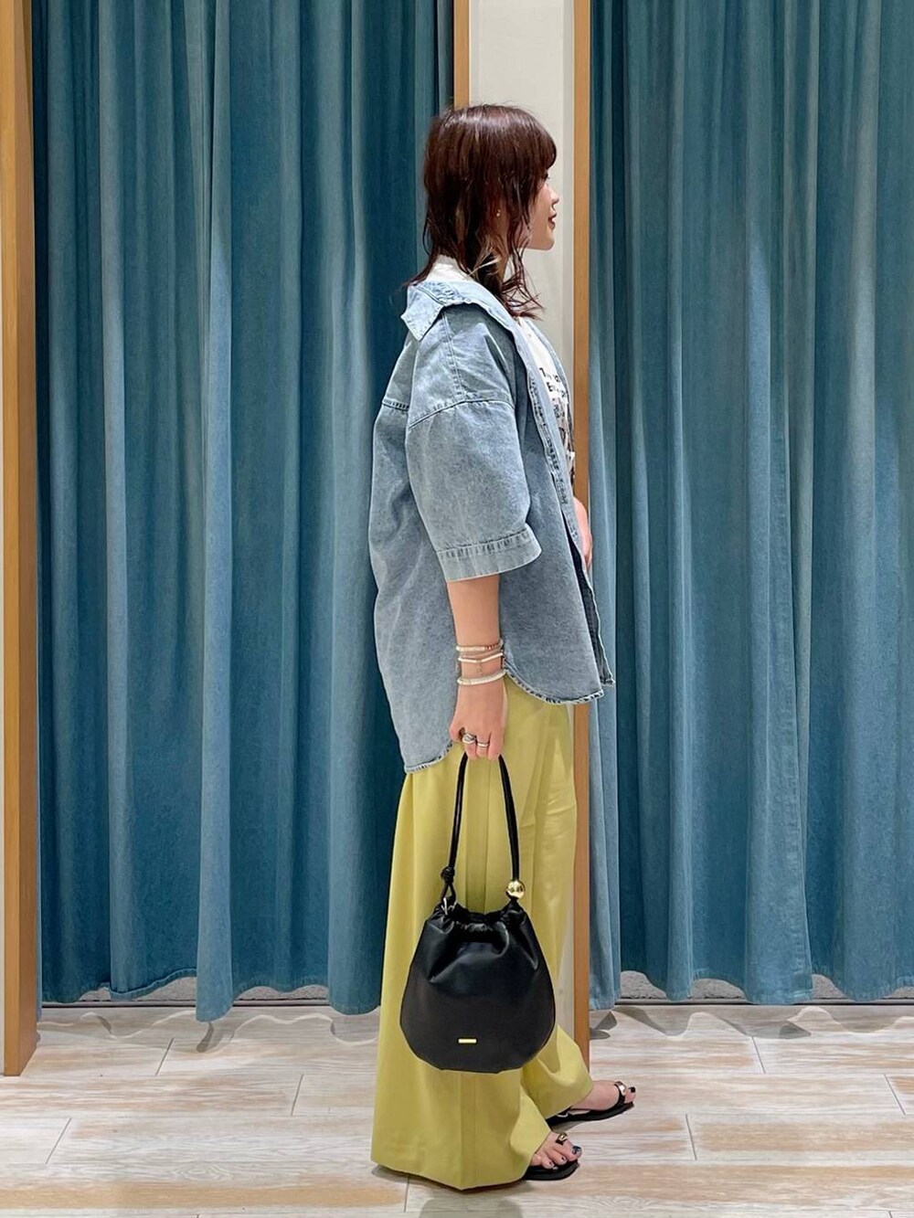 イエロー系のその他パンツ、ブラック系のショルダーバッグ、ホワイト系のTシャツ/カットソーを着用したレディースの春コーディネートの2枚目の写真