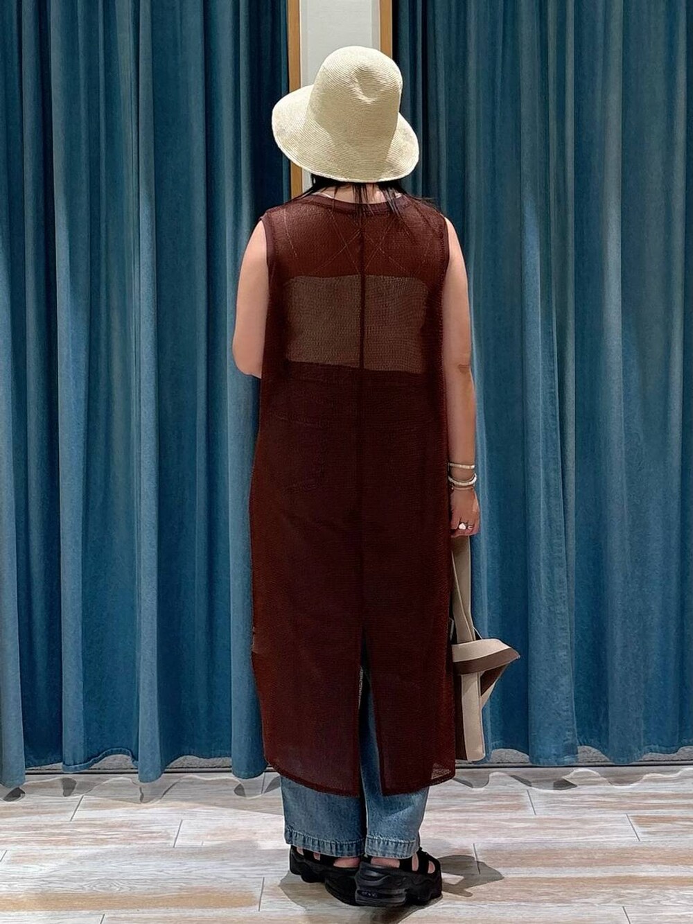 ホワイト系のキャミソール、ブルー系のデニムパンツ、ブラウン系のワンピースを着用したレディースの夏コーディネートの2枚目の写真