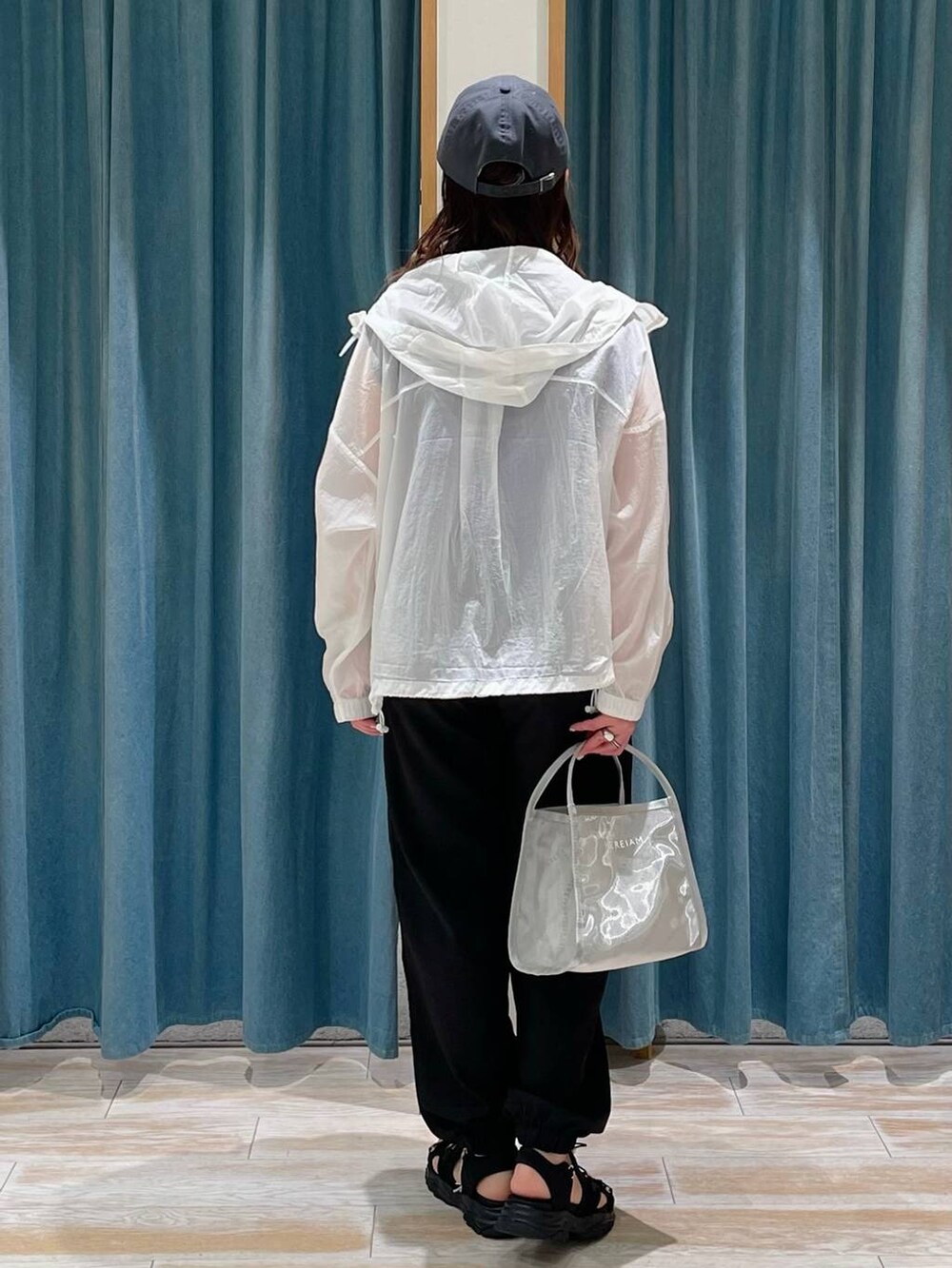 ブラック系のその他パンツ、ホワイト系のナイロンジャケット、パープル系のTシャツ/カットソーを着用したレディースの春コーディネートの3枚目の写真