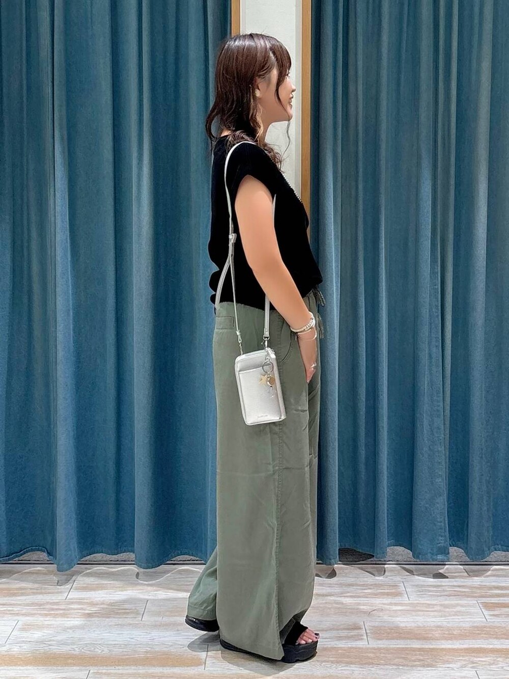 グリーン系のその他パンツ、ブラック系のTシャツ/カットソー、シルバー系の財布を着用したレディースの夏コーディネートの2枚目の写真