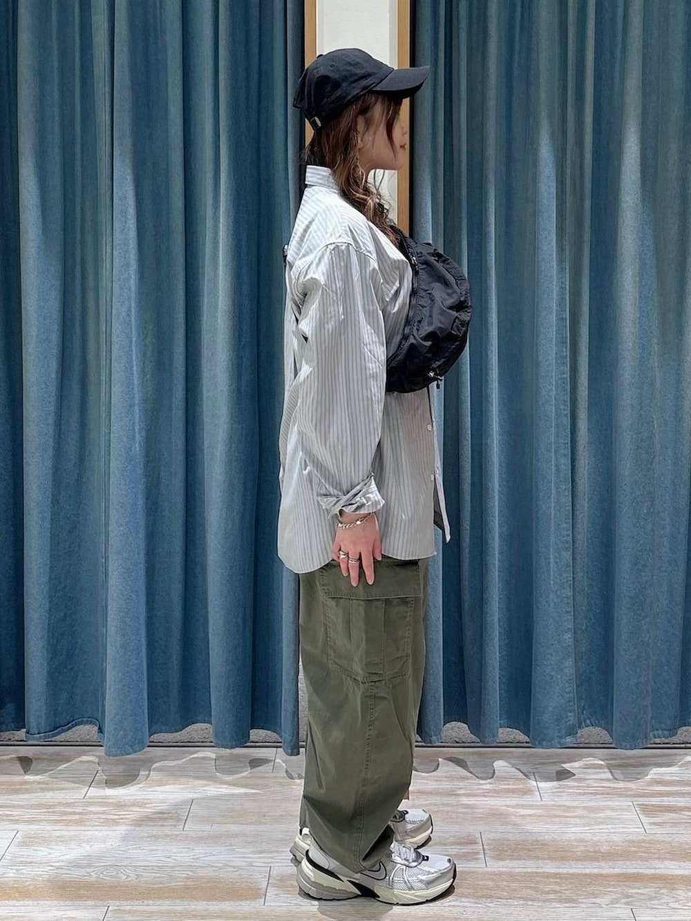 ブラック系のショルダーバッグ、グリーン系のカーゴパンツ、ホワイト系のTシャツ/カットソーを着用したレディースの春コーディネートの2枚目の写真