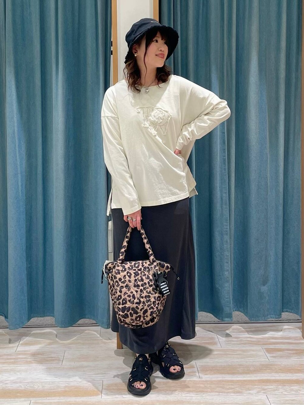 その他のトートバッグ、ブラック系のサンダル、ホワイト系のTシャツ/カットソーを着用したレディースの春コーディネートの4枚目の写真