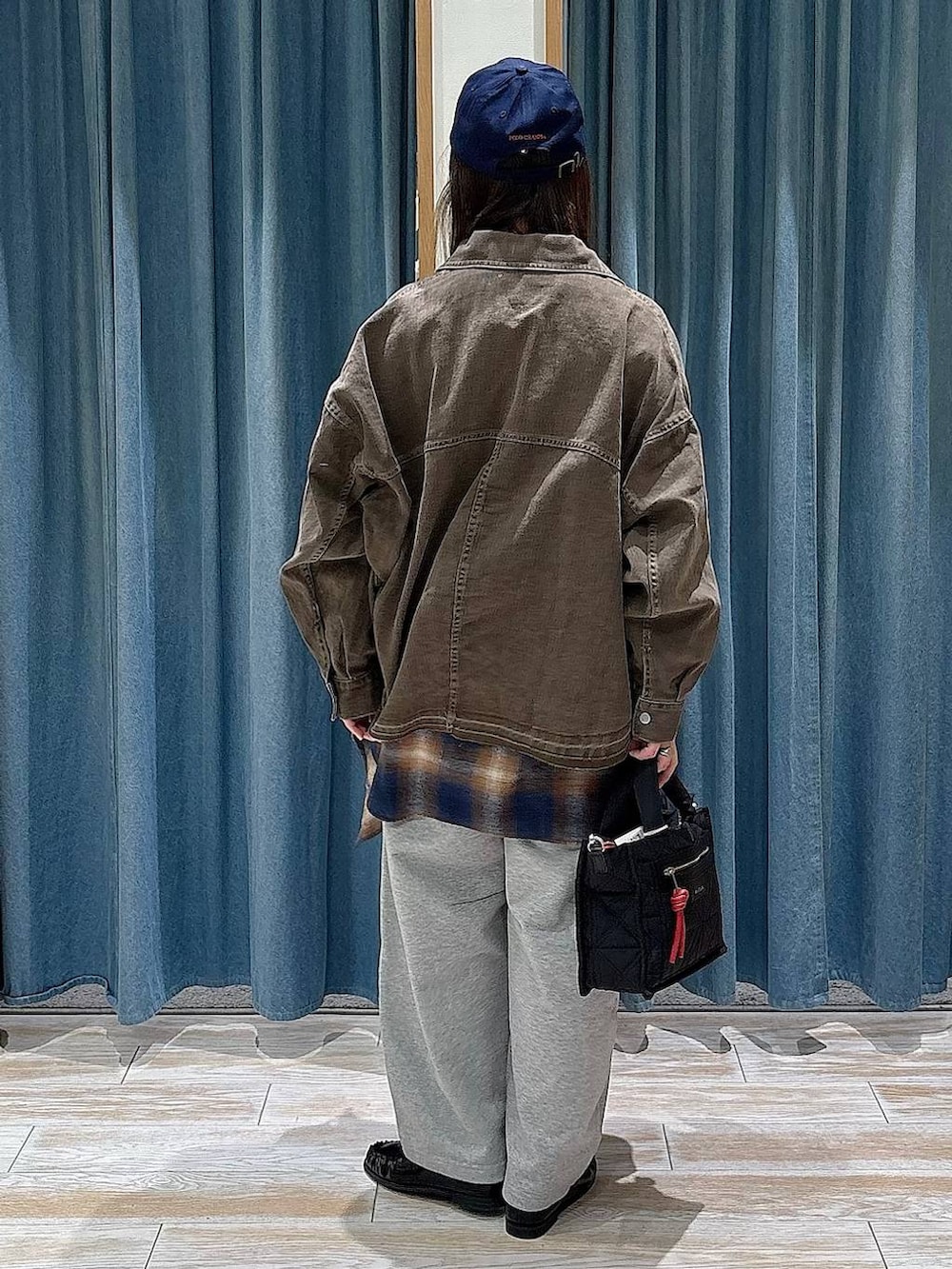 ブラック系のショルダーバッグ、ブラック系のTシャツ/カットソー、ブルー系のシャツ/ブラウスを着用したレディースの冬コーディネートの3枚目の写真