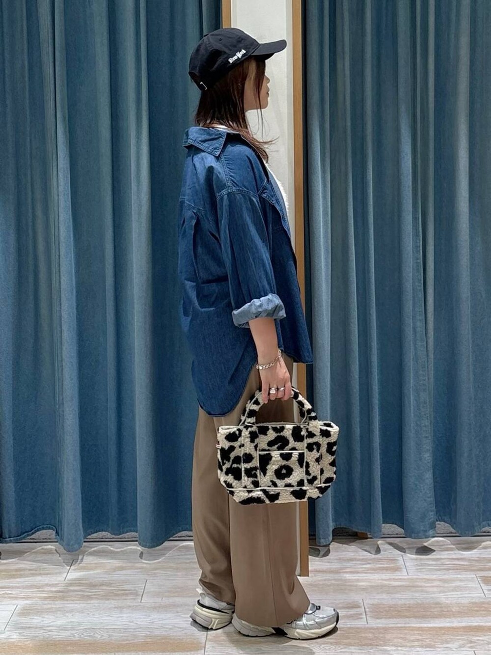 ブルー系のシャツ/ブラウス、ホワイト系のベスト、ベージュ系のトートバッグを着用したレディースの秋コーディネートの2枚目の写真