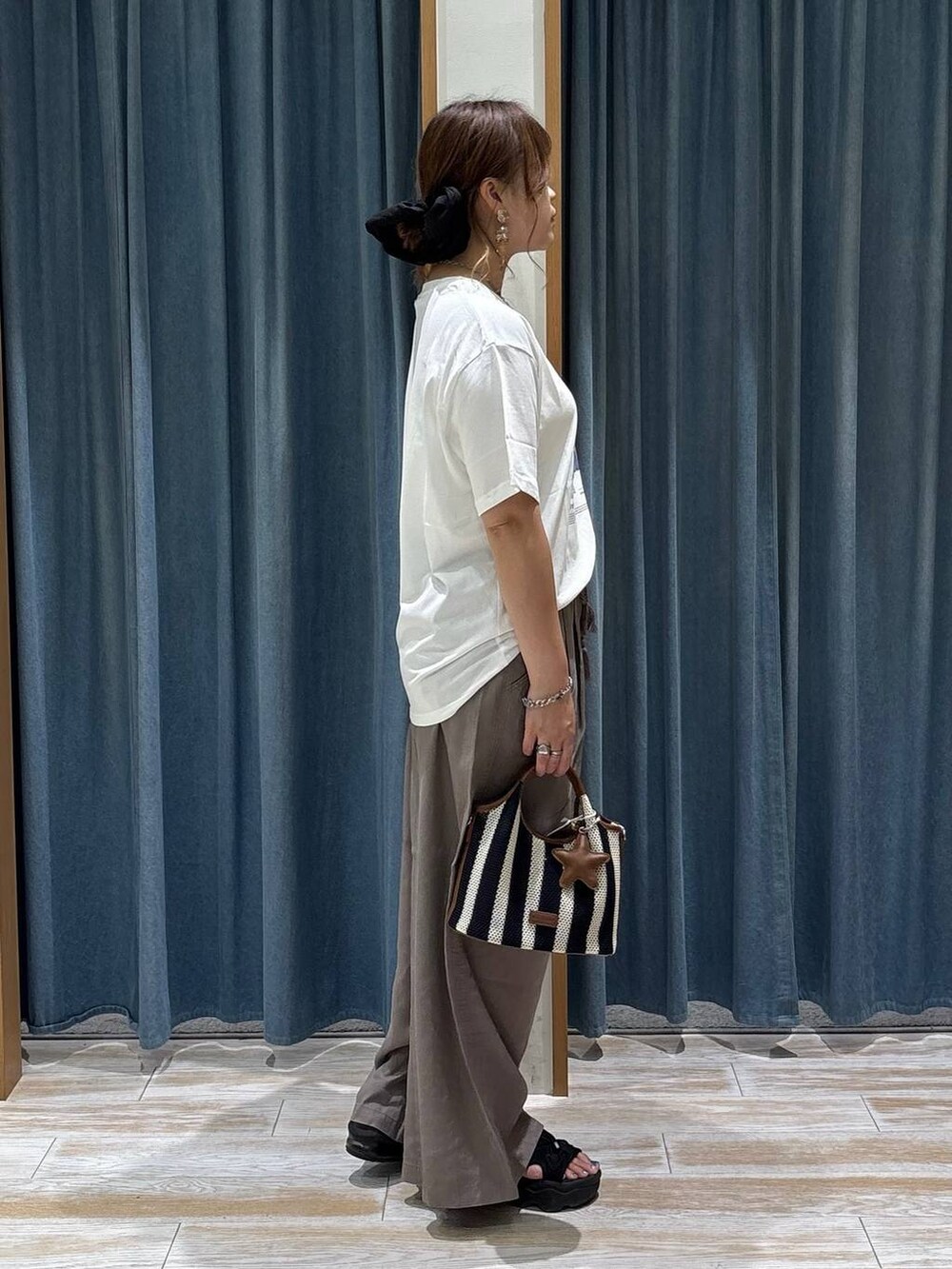 ブラウン系のその他パンツ、ブルー系のショルダーバッグ、ホワイト系のTシャツ/カットソーを着用したレディースの夏コーディネートの2枚目の写真