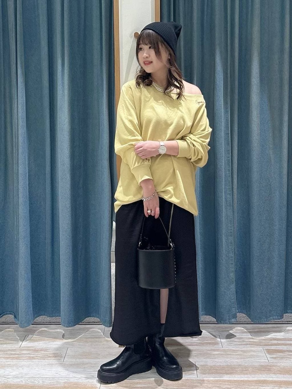 ブラック系のブーツ、イエロー系のスウェット、ブラック系のスカートを着用したレディースの冬コーディネートの4枚目の写真