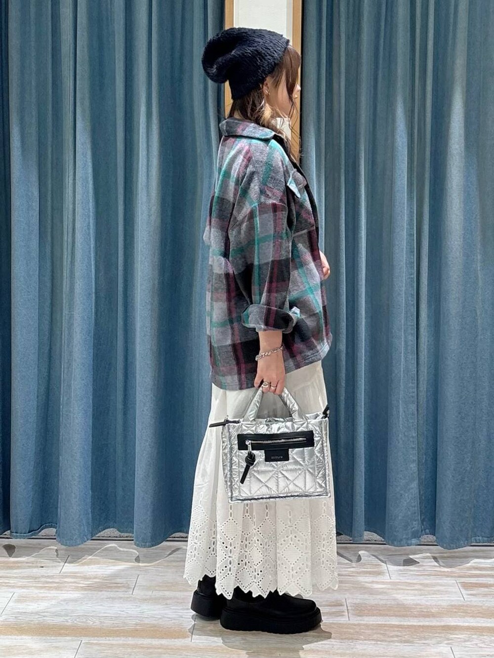 シルバー系のショルダーバッグ、グレー系のその他アウター、ブラック系のニット/セーターを着用したレディースの秋コーディネートの2枚目の写真