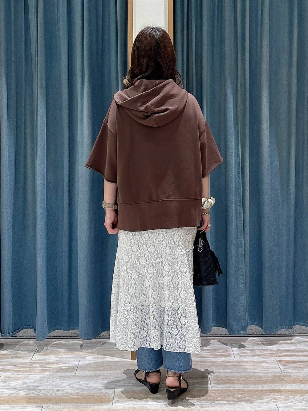 ブルー系のデニムパンツ、ブラック系のショルダーバッグ、ブラック系のサンダルを着用したレディースの春コーディネートの3枚目の写真