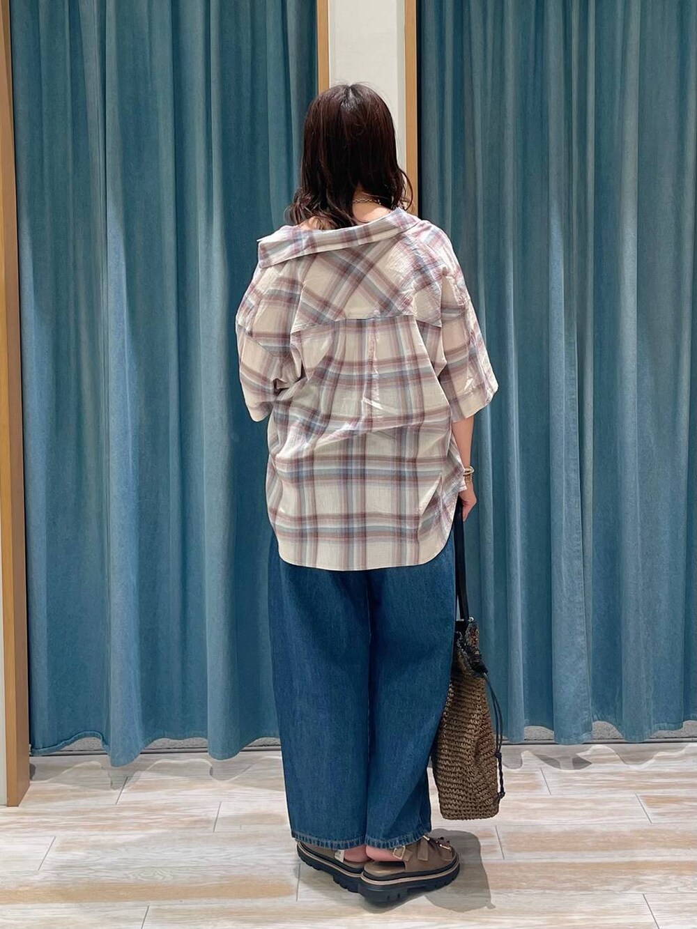 ホワイト系のキャミソール、ベージュ系のサンダル、ブルー系のデニムパンツを着用したレディースの春コーディネートの3枚目の写真
