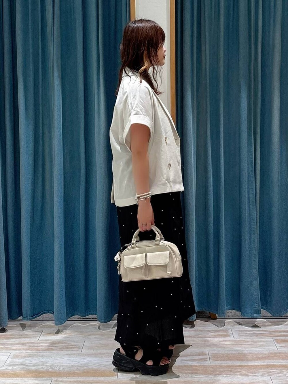ホワイト系のキャミソール、ベージュ系のその他アウター、ホワイト系のボストンバッグを着用したレディースの夏コーディネートの2枚目の写真
