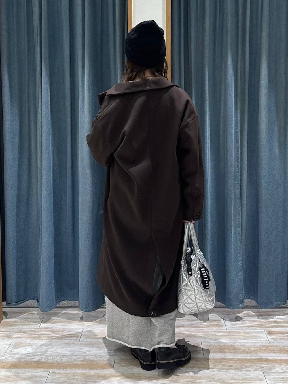 ブラウン系のチェスターコート、ブラック系のローファー、ブラウン系のニット/セーターを着用したレディースの冬コーディネートの3枚目の写真