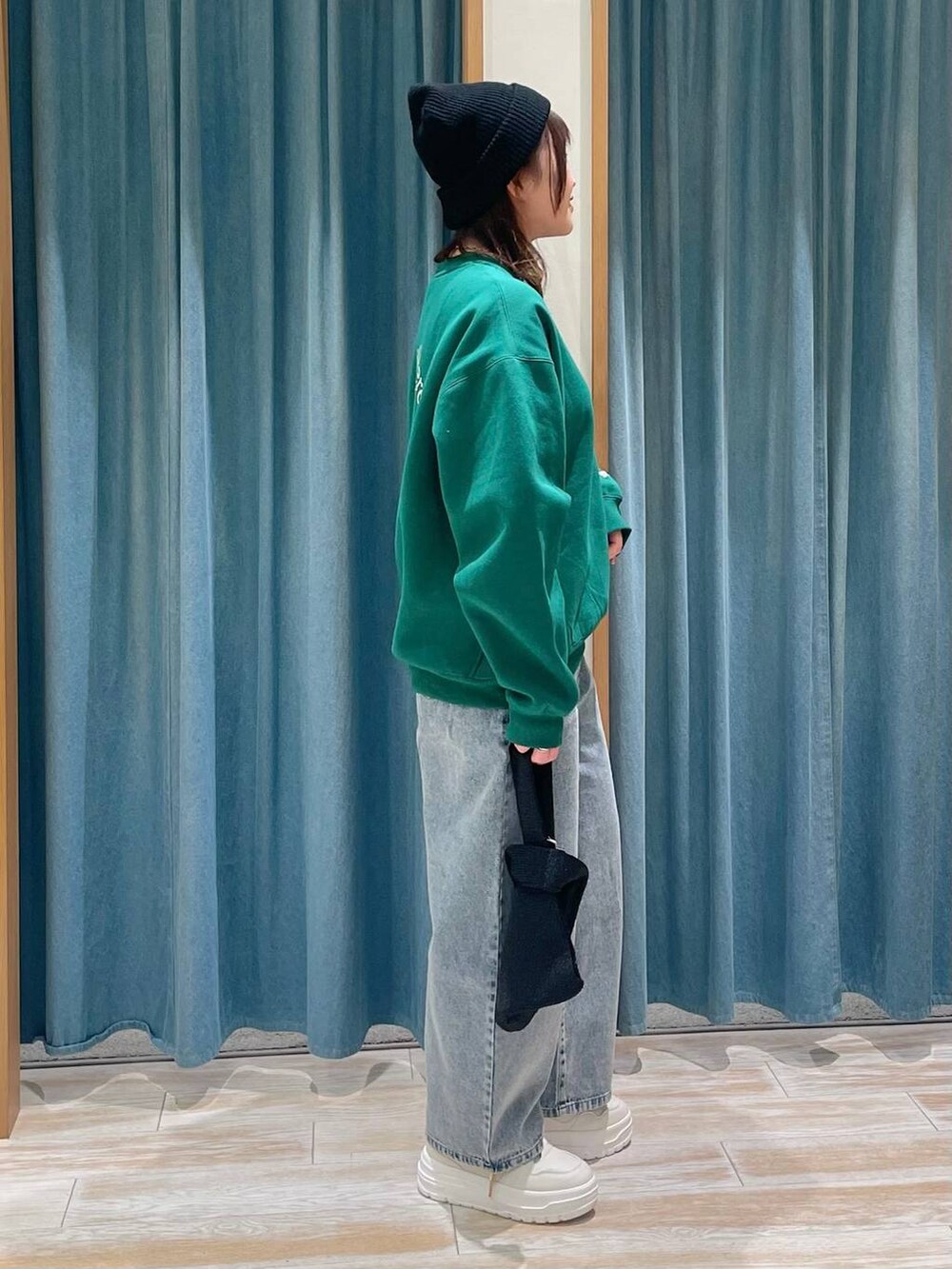 ホワイト系のスニーカー、ブルー系のデニムパンツ、ブラック系のハンドバッグを着用したレディースの冬コーディネートの2枚目の写真