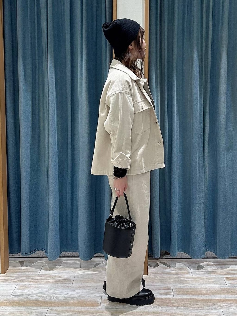 ブラック系のブーツ、ブラック系のTシャツ/カットソー、ブラック系のハンドバッグを着用したレディースの冬コーディネートの2枚目の写真