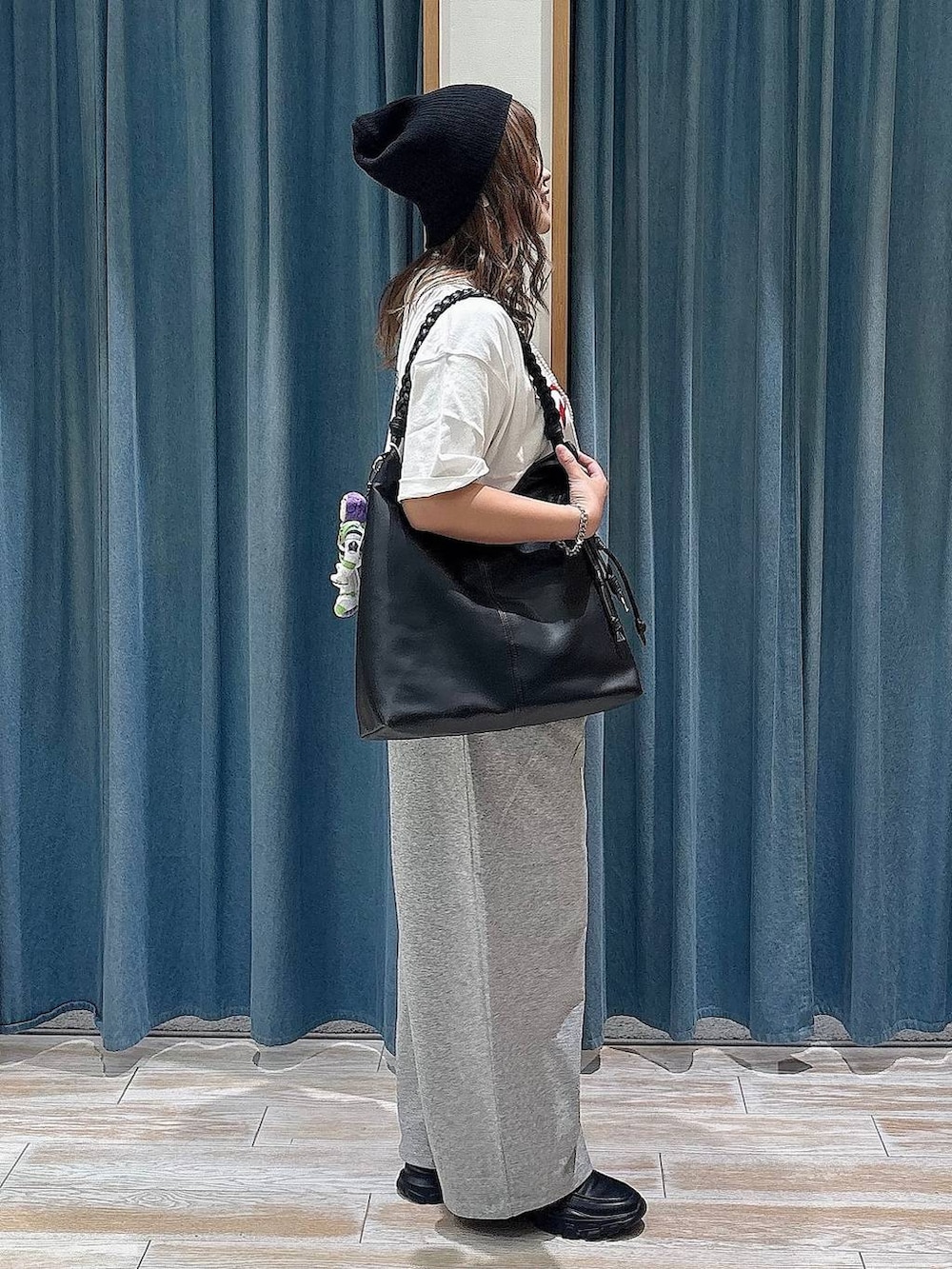 ブラック系のスニーカー、グレー系のスウェットパンツ、ブラック系のトートバッグを着用したレディースの夏コーディネートの2枚目の写真