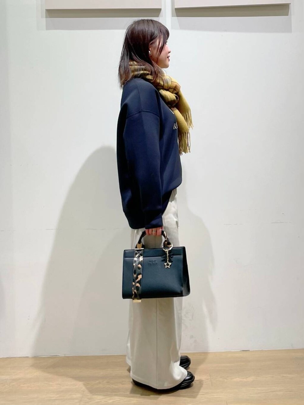 ブラック系のローファー、ブラック系のハンドバッグ、ホワイト系のその他パンツを着用したレディースの秋コーディネートの2枚目の写真