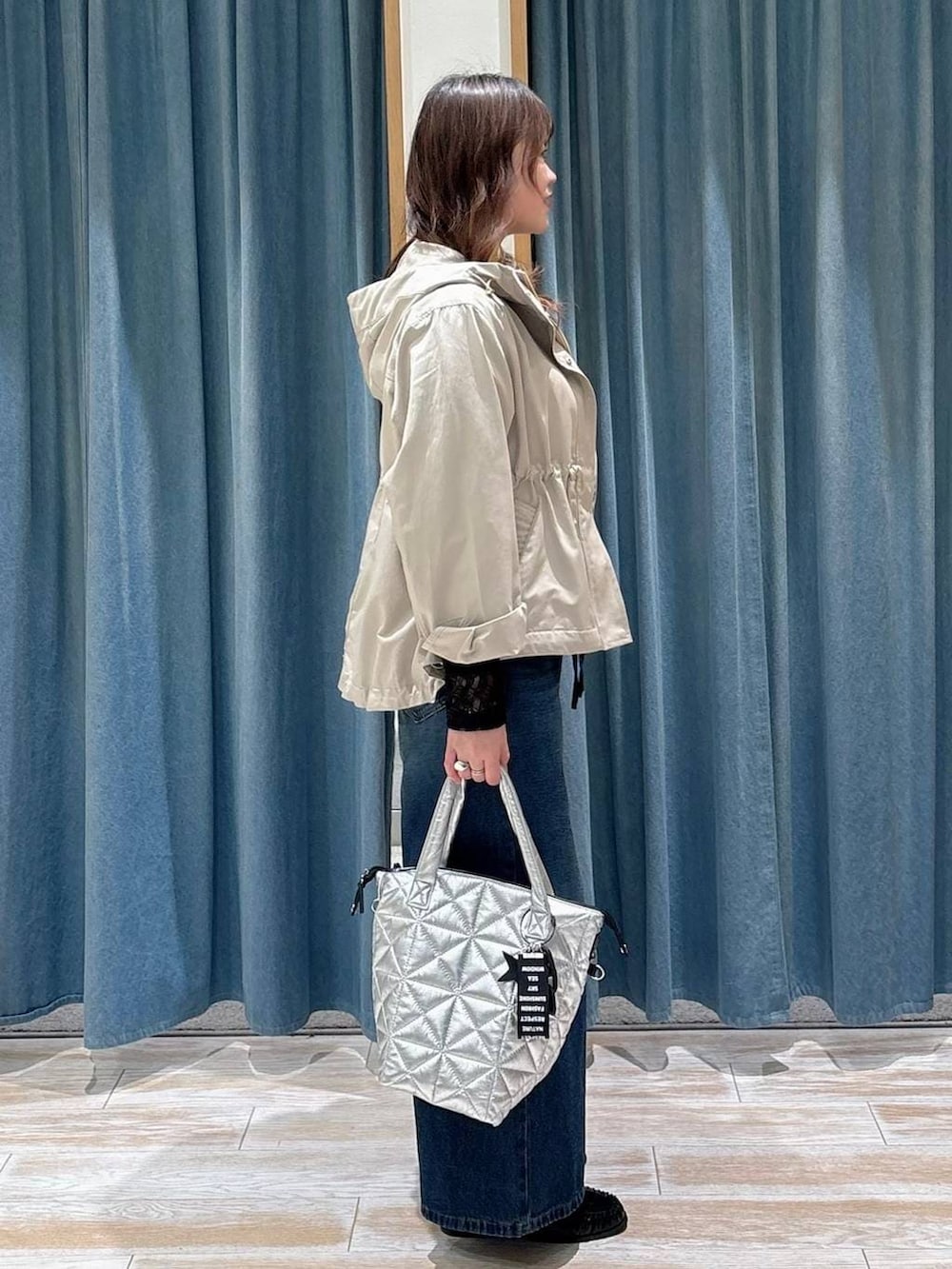 ブラック系のTシャツ/カットソー、ブルー系のデニムパンツ、ベージュ系のマウンテンパーカーを着用したレディースの春コーディネートの2枚目の写真