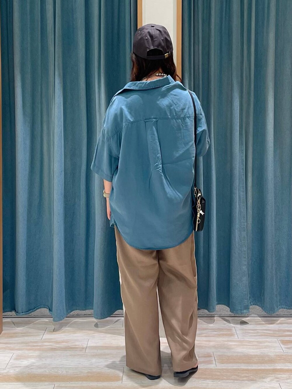 ホワイト系のキャミソール、ブルー系のシャツ/ブラウス、ブラウン系のその他パンツを着用したレディースの夏コーディネートの3枚目の写真