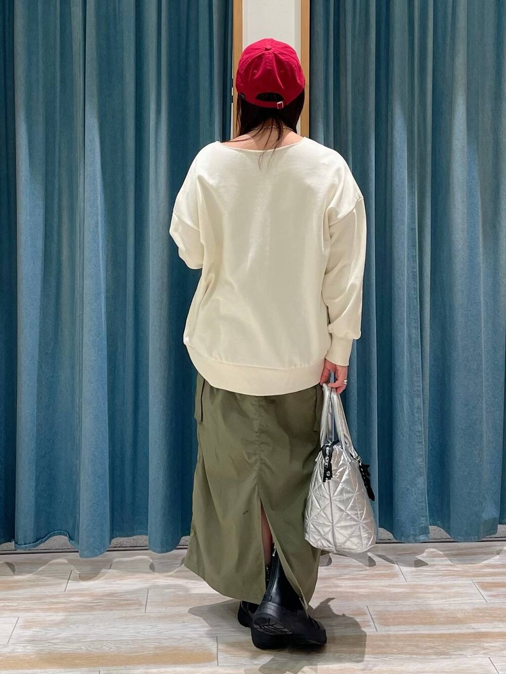 ブラック系のブーツ、ホワイト系のスウェット、シルバー系のトートバッグを着用したレディースの冬コーディネートの3枚目の写真