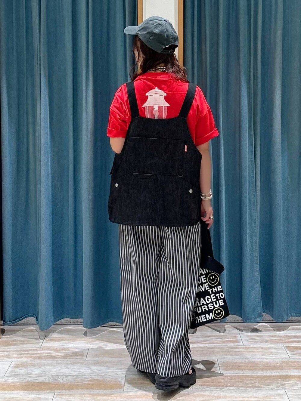 ブラック系のトートバッグ、レッド系のTシャツ/カットソー、その他のベストを着用したレディースの夏コーディネートの3枚目の写真