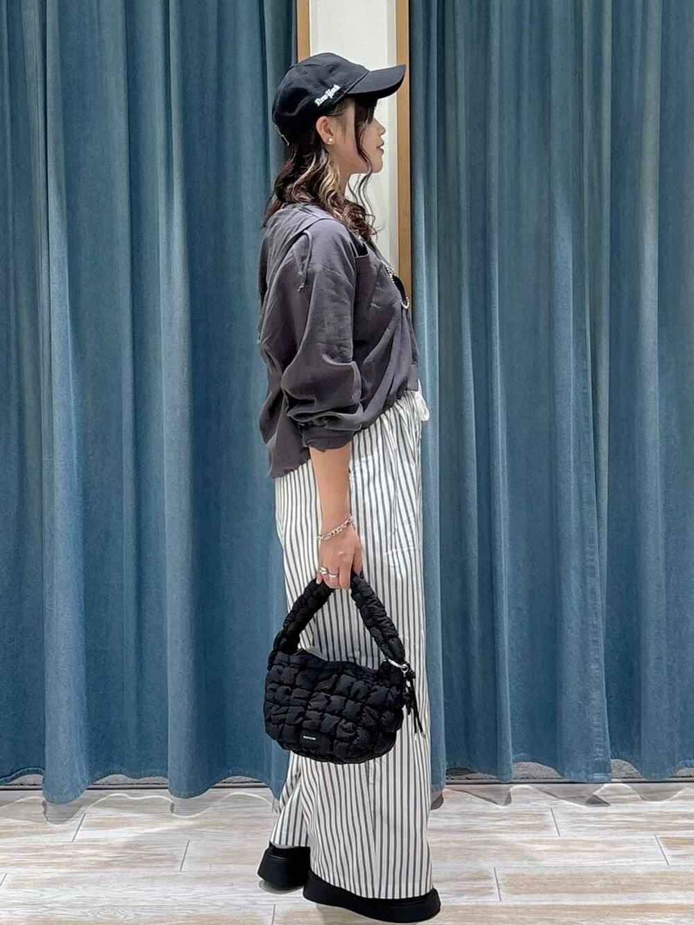 ブラック系のハンドバッグ、ブラック系のサンダル、ホワイト系のその他パンツを着用したレディースの秋コーディネートの2枚目の写真