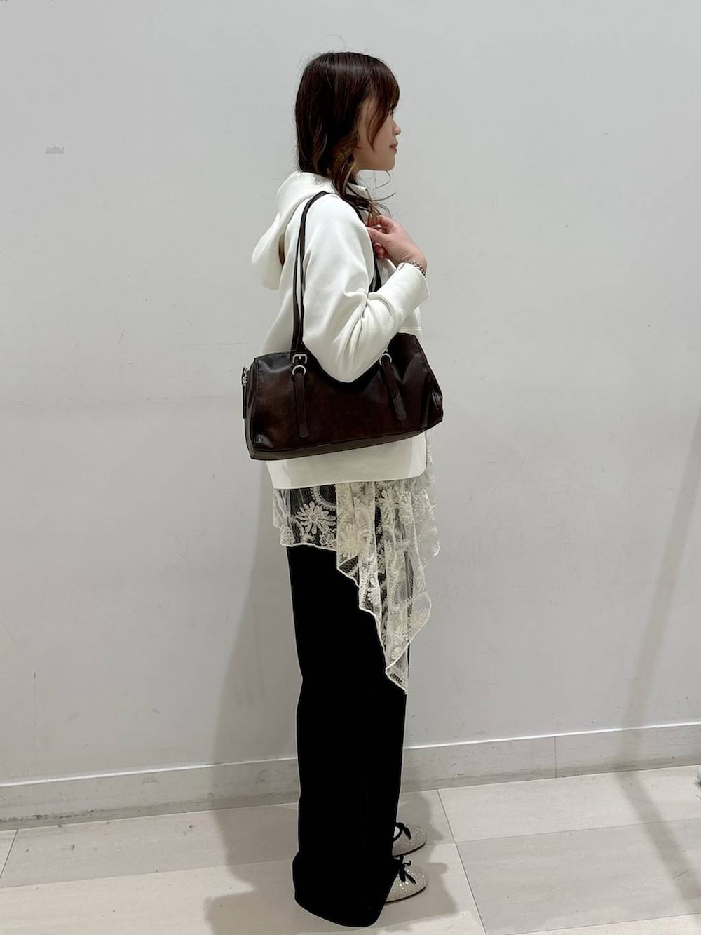 シルバー系のバレエシューズ、ホワイト系のパーカー、ホワイト系のその他トップスを着用したレディースの冬コーディネートの2枚目の写真