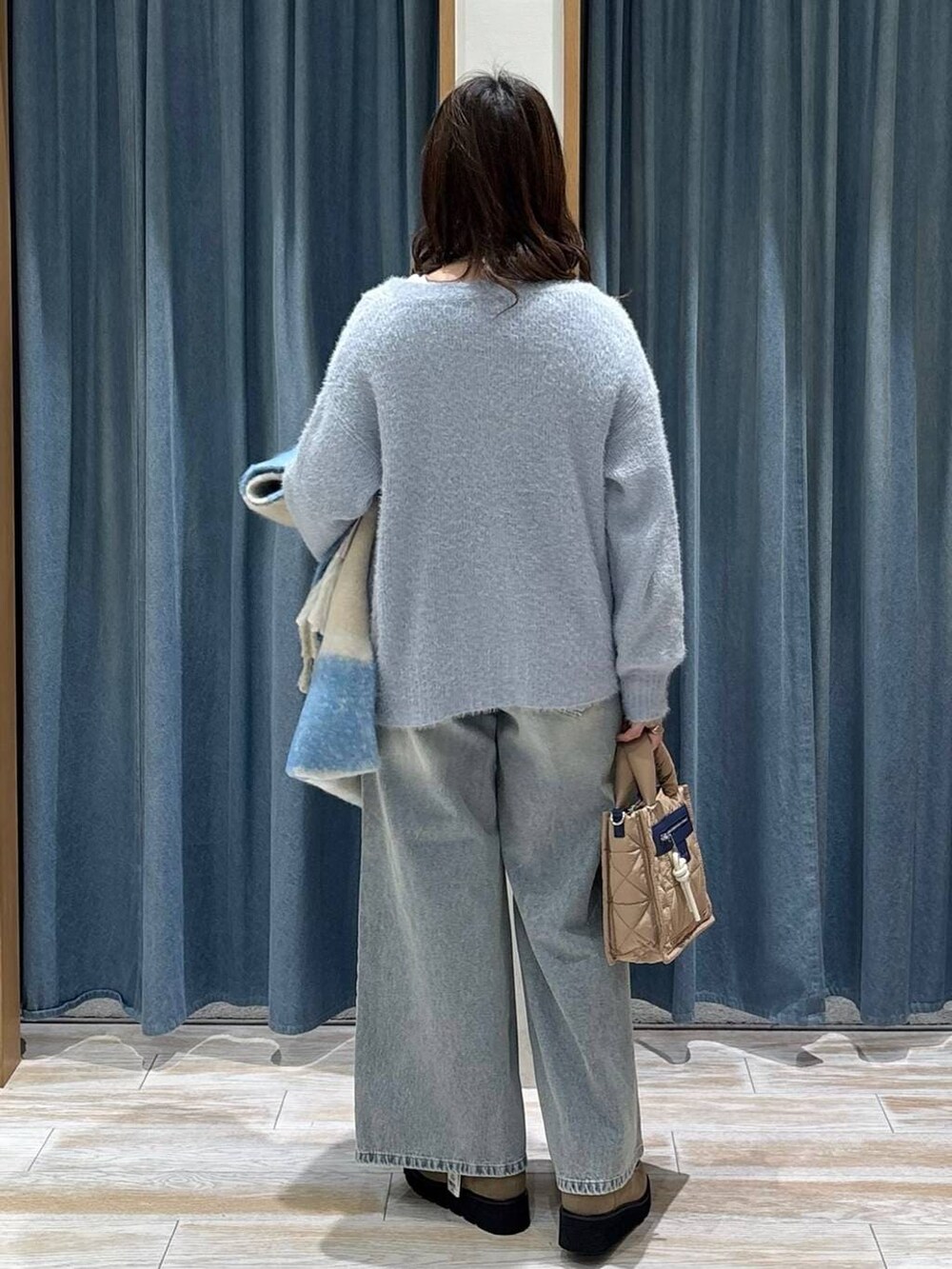 ベージュ系のショルダーバッグ、ホワイト系のTシャツ/カットソー、ベージュ系のブーツを着用したレディースの秋コーディネートの3枚目の写真