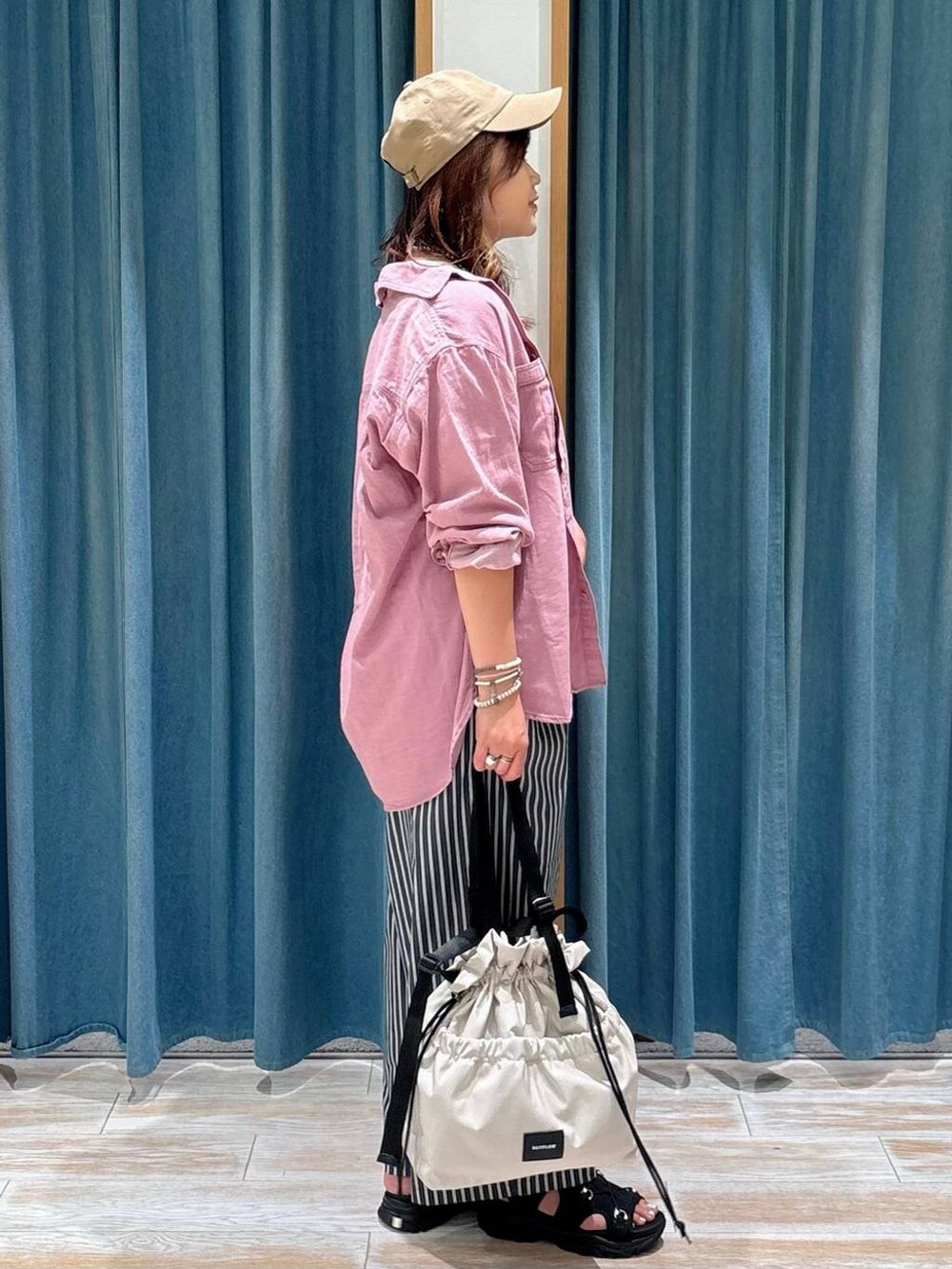 ブラック系のキャミソール、ホワイト系のトートバッグ、ブラック系のサンダルを着用したレディースの夏コーディネートの2枚目の写真