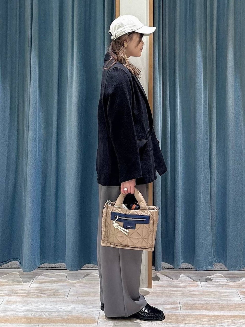 ベージュ系のショルダーバッグ、ホワイト系のTシャツ/カットソー、ブラック系のローファーを着用したレディースの春コーディネートの2枚目の写真