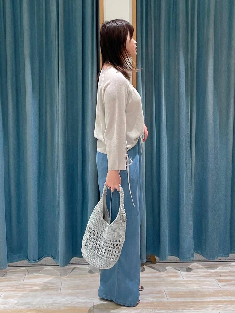 シルバー系のサンダル、グレー系のハンドバッグ、ブルー系のその他パンツを着用したレディースの春コーディネートの2枚目の写真