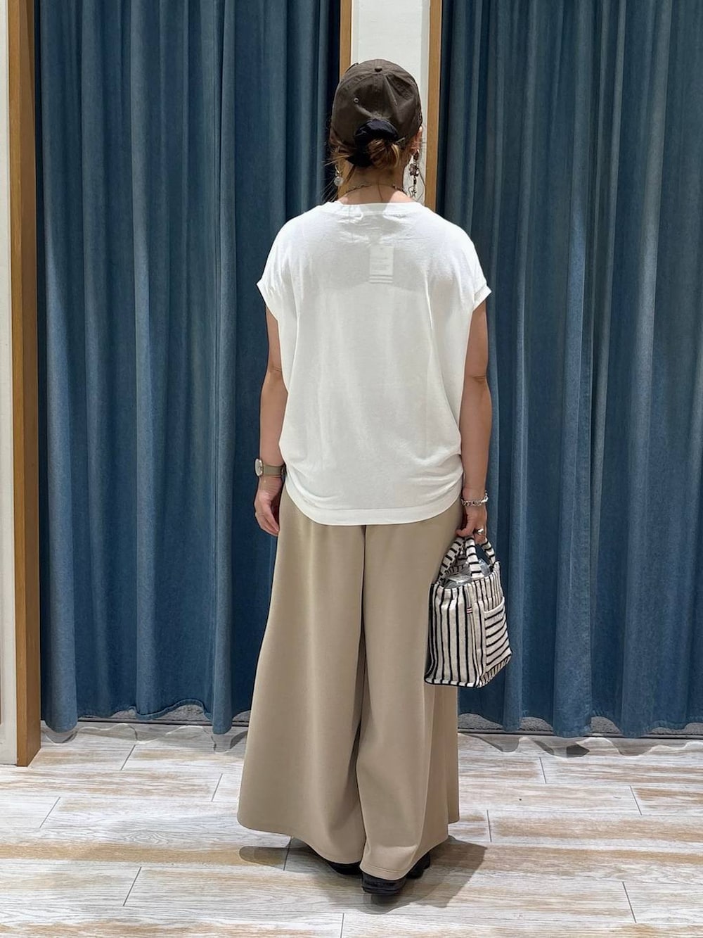 ホワイト系のTシャツ/カットソー、ベージュ系のトートバッグ、ベージュ系のその他パンツを着用したレディースの夏コーディネートの2枚目の写真