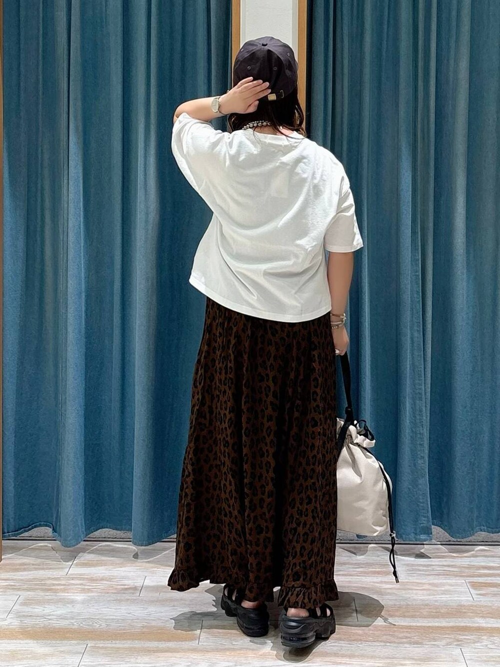 ホワイト系のトートバッグ、ブラウン系のスカート、ホワイト系のTシャツ/カットソーを着用したレディースの夏コーディネートの3枚目の写真