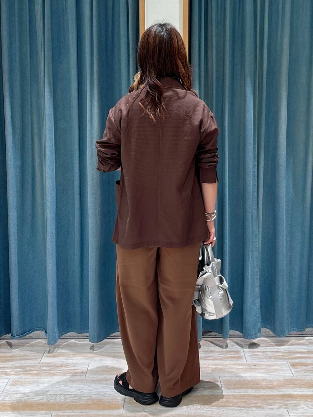 ブラック系のサンダル、ブラウン系のその他パンツ、ブラウン系のテーラードジャケットを着用したレディースの夏コーディネートの3枚目の写真