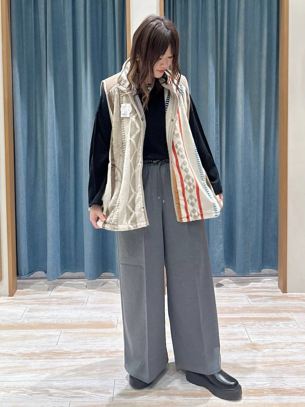 グレー系のその他パンツ、ブラック系のブーツ、ブラック系のニット/セーターを着用したレディースの冬コーディネートの4枚目の写真