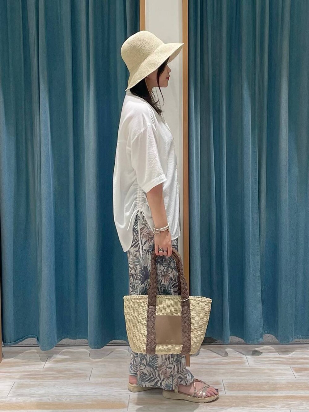 ベージュ系のトートバッグ、グリーン系のその他パンツ、ゴールド系のサンダルを着用したレディースの春コーディネートの2枚目の写真